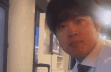 a young man in a white shirt and tie is making a funny face .