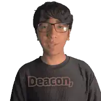 a man wearing glasses and a black shirt that says deacon on it