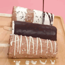 three different flavors of ice cream bars are on a wooden cutting board