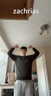 a man flexes his muscles with the name zachrias written above him
