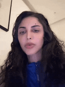 a close up of a woman 's face with a blue shirt on
