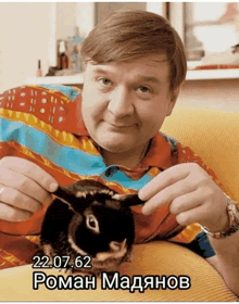 a man is holding a rabbit with the date 22.07.62 on the bottom