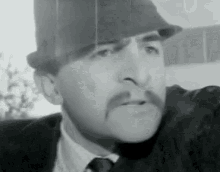 a man with a mustache is wearing a top hat and a suit .
