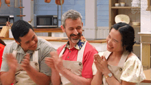 a group of people are clapping in a kitchen with the great canadian baking show written on the bottom