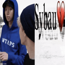 a man wearing a blue wtaps hoodie stands next to a man wearing a black beanie