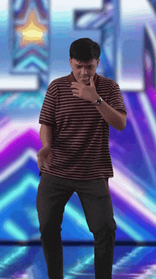 a man in a striped shirt and black pants is dancing