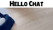 a blue towel sits on a wooden floor with the words hello chat below it