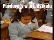 a girl sits at a desk in a classroom with the words pawlowicz w przedszkolu