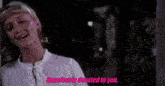 a woman in a white shirt says hopelessly devoted to you in pink letters
