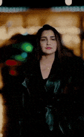 a woman in a black leather jacket is holding a bouquet of roses