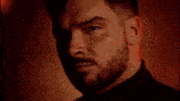 a close up of a man with a beard looking at the camera .