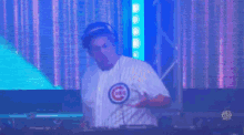 a man wearing a chicago cubs jersey is dancing on a stage