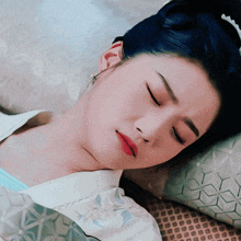 a woman with blue hair is sleeping on a bed