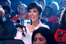 a woman is holding a camcorder that says ' nikon ' on the front