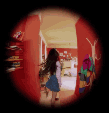 a woman in a blue skirt stands in a hallway