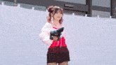 a woman in a red top is holding a gun