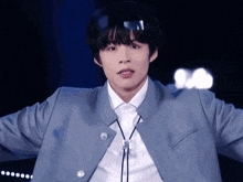 a young man wearing a blue jacket and a white shirt with a tie around his neck
