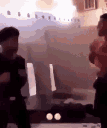 two people are standing in front of a plane that is flying in the air