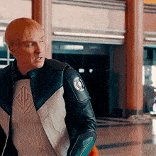a man wearing a superhero costume is standing in a hallway .