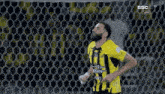 a man in a yellow and black striped shirt with ssc on the bottom
