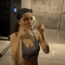 a woman in a sports bra is giving the middle finger to the camera