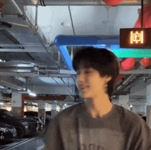 a man standing in a parking garage with a sign above him that says ' i '