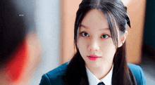 a girl in a school uniform with a bow in her hair looks at something