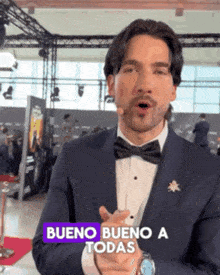 a man in a tuxedo and bow tie says bueno bueno a todas in spanish