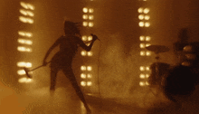 a woman is singing into a microphone in front of a drum set