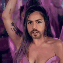 a woman with a beard and a tattoo of a trumpet on her arm .