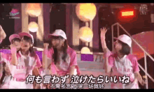 a group of girls wearing pink shirts and white hats are singing into microphones in front of a sign that says bs live