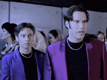 a man in a purple jacket is standing next to another man