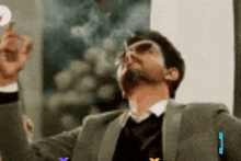 a man in a suit and tie is smoking a cigarette and looking up at something