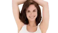 a woman in a white tank top is smiling with her arms up