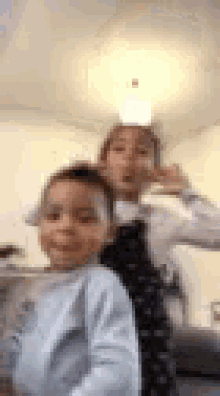 a boy and a girl are standing next to each other and making funny faces .