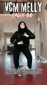 a woman in a hijab is dancing in front of a sign that says vcm melly eagle ob