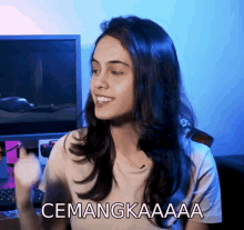 a woman with long dark hair is smiling and says " cemanggaaaa "