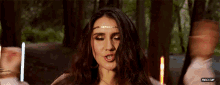 a woman with a gold headband on her head is singing