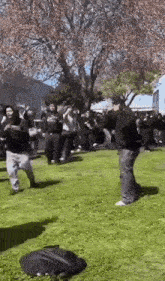 a group of people are standing in a grassy area .
