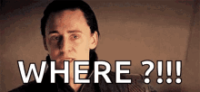 a man is sitting down and looking at the camera with the words `` where ? '' written on his face .