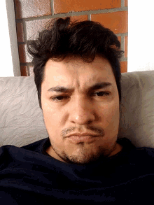 a man with a beard and a black shirt is laying down