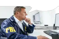 a man in a fbi jacket is looking at a computer screen .
