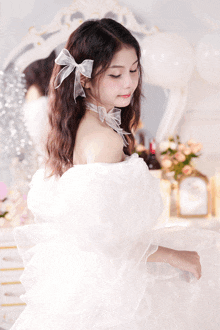 a woman in a white dress with a bow on her hair
