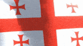 a close up of a red and white flag with crosses on it