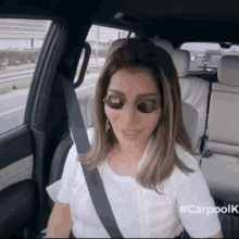 a woman wearing sunglasses is sitting in the back seat of a car with #carpolk written on the side