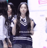 a girl with long hair is wearing a blue vest and a white shirt