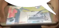 a person is playing a game on a tablet with a speech bubble above it