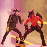 a man in a cowboy hat is standing next to a devil with horns