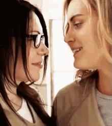 two women are looking at each other with glasses on .