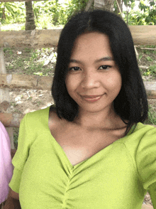 a woman wearing a green sweater is smiling for the camera